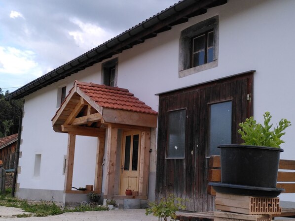 A building with a wooden porch, a door, and a window.