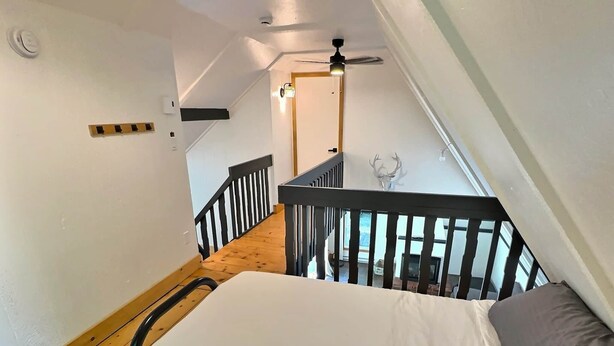 A narrow staircase with wooden steps and black railings leading to a landing. - Chalets Cheribourg - Le 144 - Spa (Orford)