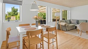 A modern interior with a dining area, a sofa, and a view of the outdoors. - "Gertraud" - 600m from the sea by Interhome (Væggerløse)