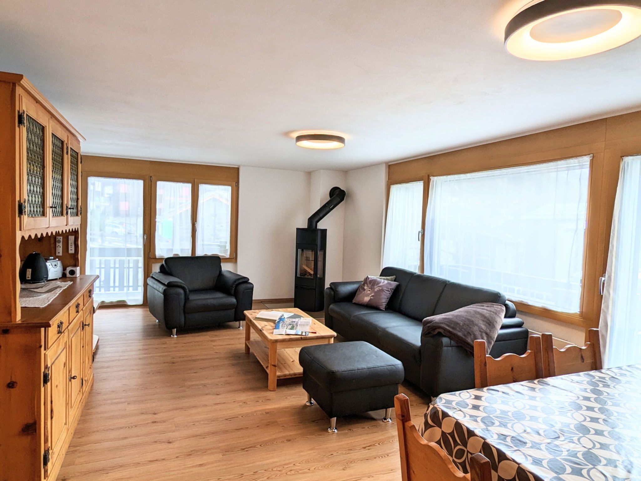 Un salon comprenant un canapé, un fauteuil, une table basse en bois et une cheminée.