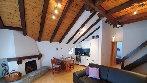 Una sala de estar acogedora con chimenea, un comedor y una cocina.