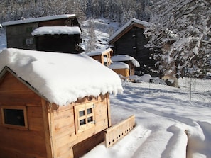 A wooden cabin with a snow-covered roof, surrounded by a snowy landscape and trees. - Bergdohle, (Randa), by Interhome (Randa)