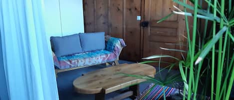 Une cabane en bois avec un canapé et un banc.