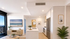 Un apartamento moderno con sala de estar, cocina y un balcón con vistas a la ciudad.