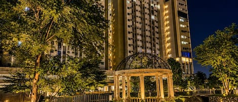 A multi-story building with a central courtyard, a gazebo, and surrounding greenery.