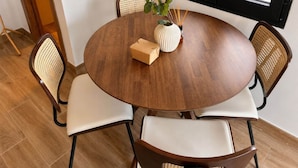 A round wooden dining table with four chairs, a vase with a plant, and a small box on the table. - Flat Near Metro, Madrid (Madrid)