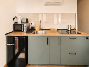 A modern kitchen with a microwave, toaster, sink, and a coffee maker. - Flat Near Metro, Madrid (Madrid)
