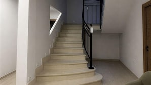 A staircase with a black railing, beige carpeted steps, and a light-colored floor. - Flat Near Metro, Madrid (Madrid)