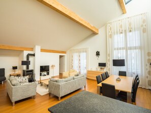 A spacious living room with a fireplace, a dining area with a table and chairs, and a separate seating area with sofas.