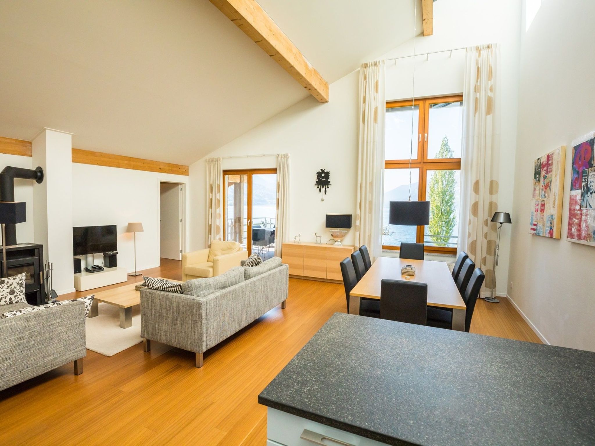 A modern living room with a sofa, dining table, and a TV.