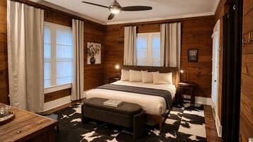 A bedroom with a bed, a desk, a chair, a ceiling fan, and a rug.