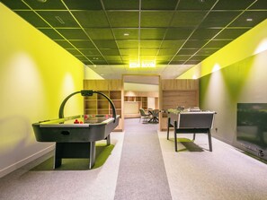 A room with a foosball table, a pool table, a television, and a seating area with chairs and a table. - Les Hauts de Vaujany by Interhome (Vaujany)