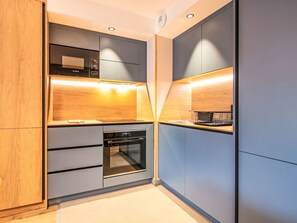 Een moderne keuken met ingebouwde apparatuur, houten kastjes en een strak design.