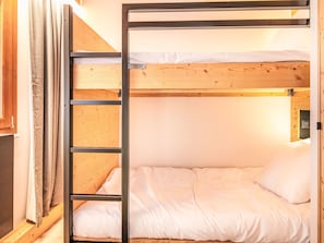 A bunk bed with a wooden frame and white bedding. - Les Hauts de Vaujany by Interhome (Vaujany)