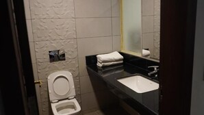 A bathroom with a toilet, sink, and mirror.