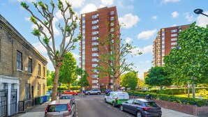 A street with parked cars, a cyclist, and tall residential buildings. - New * Zone 1 - 2 bed slps 5 quiet modern 800mps Wifi a home from home! (London)