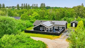 A house with a fenced yard, solar panels, and a gravel driveway. - Large holiday home close to the beach (Ebeltoft)