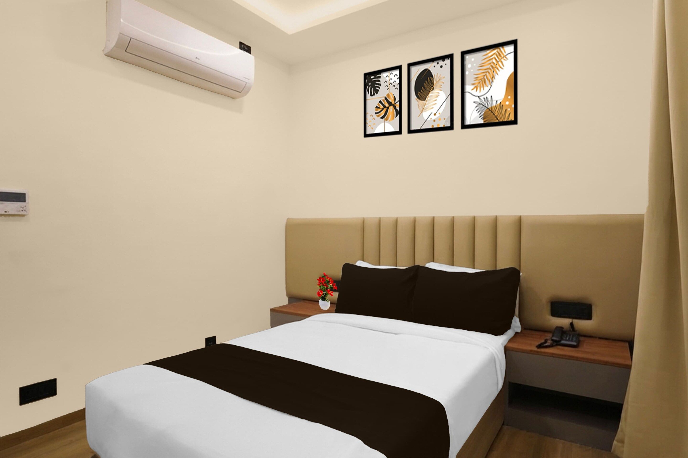 Quarto de hotel com cama, mesas de cabeceira, ar condicionado e obras de arte nas paredes.