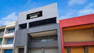 Un immeuble moderne avec une enseigne indiquant « TOWHOUSE OYO – Services inclus ».
