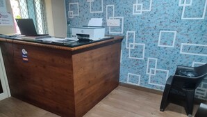 Una recepción con detalles de madera, un dispensador de agua e impresora.