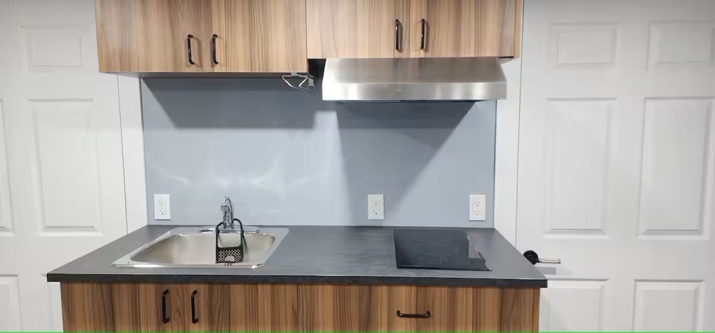 A kitchen with wooden cabinets, a stainless steel sink, and a modern stove.