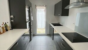 Una cucina moderna con mobili scuri, un'isola centrale e vista all'esterno.