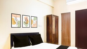 Una camera da letto con un letto, un armadio e tre quadri appesi al muro.