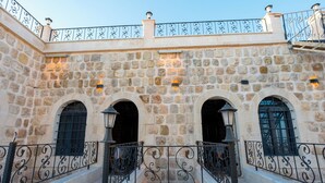Un edificio de piedra con ventanas de arco y barandilla de hierro forjado.