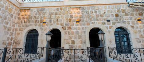 A stone building with arched windows and a wrought iron railing.