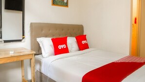 A bedroom with a bed, a bedside table, a mirror, and a painting on the wall. - Luxury Deluxe DBL Retreat W/ Free Wifi and Parking (Jakarta)