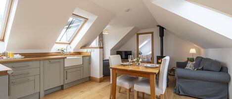 A modern loft with a kitchen, dining area, and seating space.