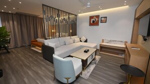 A modern living room with a sofa, armchair, coffee table, and a TV.
