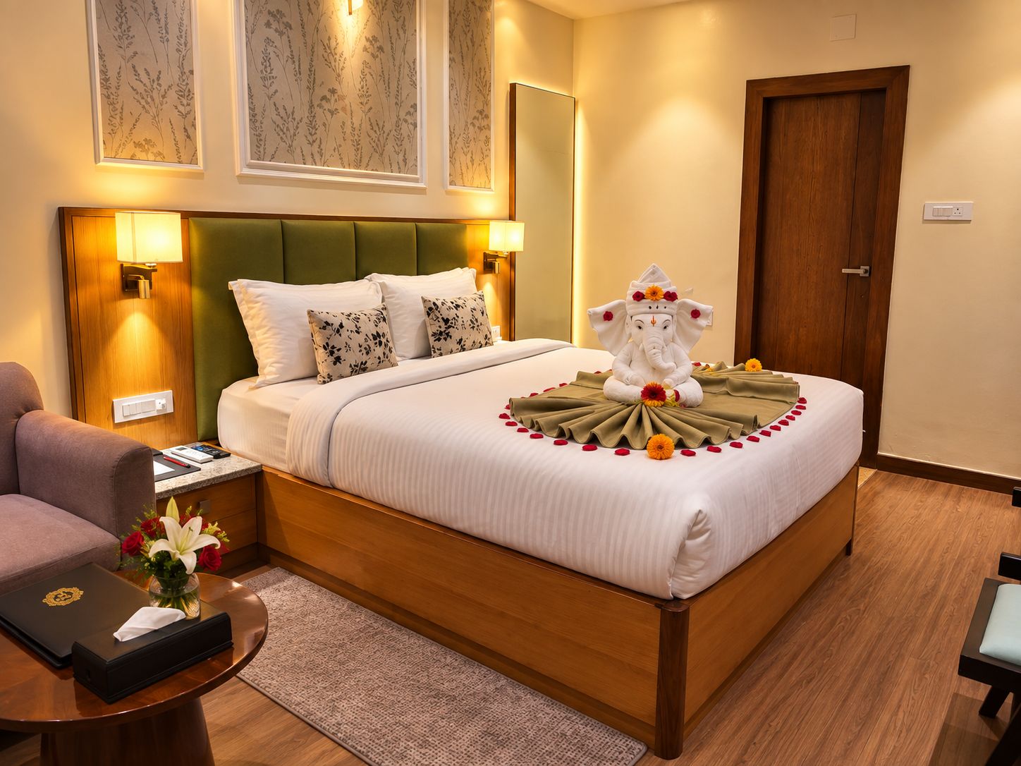 A hotel room with a bed, a green headboard, a wooden nightstand, a desk, and a chair.