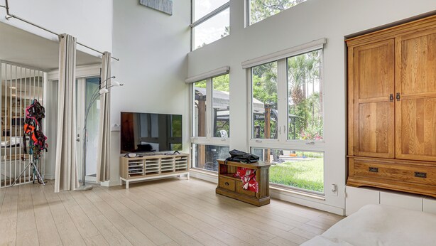 Ein geräumiges Zimmer mit einem großen Bett, einem Fernseher und einer Holzkabine.