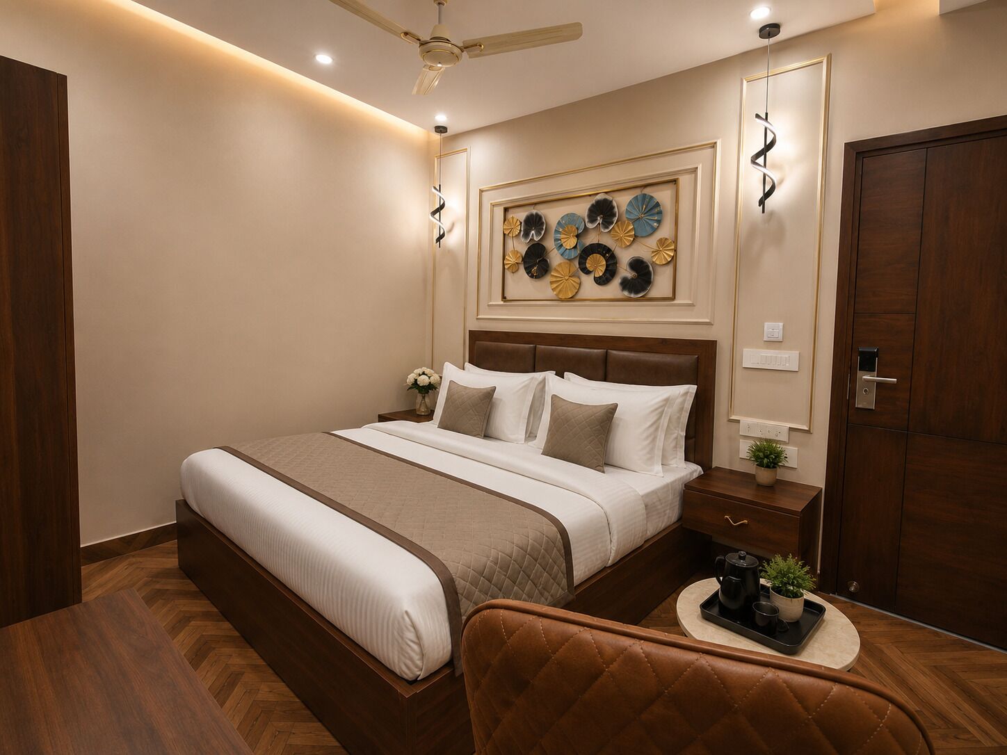A bedroom with a bed, a nightstand, a chair, a ceiling fan, and a door.