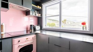 Een keuken met een raam, een broodrooster en een koffiezetapparaat.