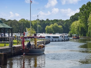 A canal with boats docked, a green-roofed structure, and a statue. - 2 bedroom accommodation in Stalham Staithe (Stalham Staithe)