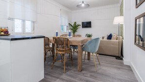 A modern kitchen with a dining area, a flat-screen TV, and a sofa. - Zurbano Pad Near Castellana (Madrid)