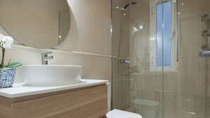 A modern bathroom with a glass-enclosed shower, a white sink, and a toilet. - Zurbano Pad Near Castellana (Madrid)