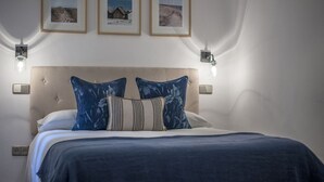 A bedroom with a bed, a headboard, two wall-mounted lights, and three framed pictures on the wall. - Zurbano Pad Near Castellana (Madrid)