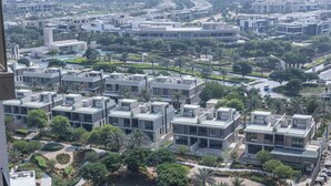 A modern residential area with contemporary buildings, green spaces, and a clear view of the surrounding cityscape. - Bloomfields 1BR - Golf Ville - DXB Hills (Dubai)