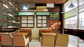 Ein Restaurantinneres mit Sitzecken, Tischen und Blick durch das Fenster.