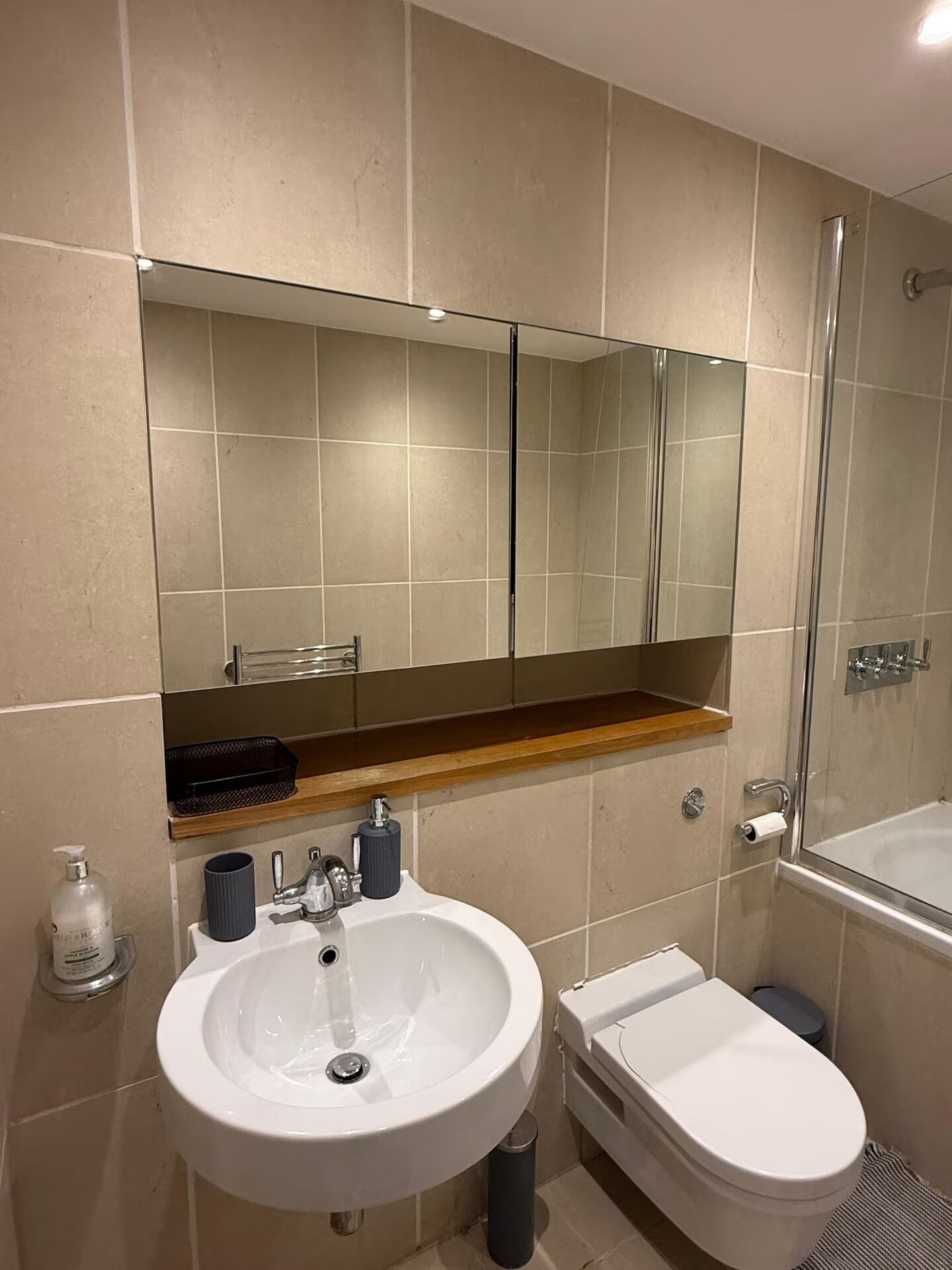 A bathroom with a sink, toilet, and a glass shower enclosure.