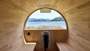 A wooden cabin with a large arched window, a built-in heater, and wooden benches. - Oku Fuji Lakeside (kawaguchiko Town, Minamitsuru-gun)