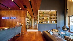 A modern interior with a wooden wall, a neon sign, a bar area, and a seating area with a fireplace. - Oku Fuji Lakeside (kawaguchiko Town, Minamitsuru-gun)