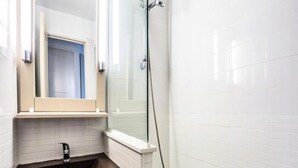 A bathroom with a sink, mirror, and shower. - Residence The Parks of Grimaud (Grimaud)