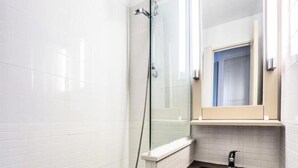 A bathroom with a shower, a sink, and a mirror. - Residence The Parks of Grimaud (Grimaud)