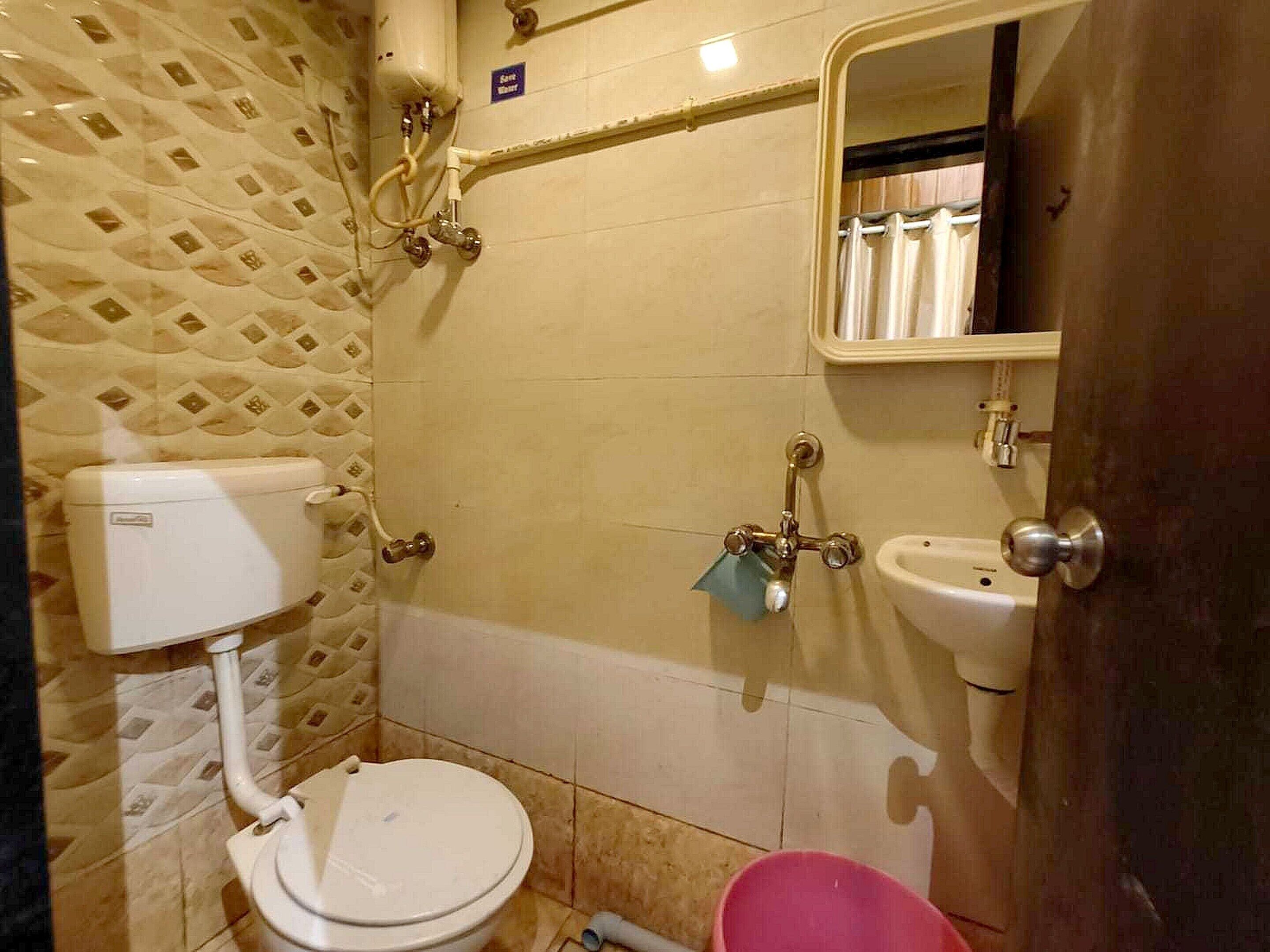 A bathroom with a toilet, sink, and shower.