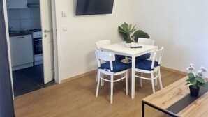 A modern kitchen with white cabinets, a stove, and a sink. - 10 Min to Westbahnhof 1BR with Living (Wien)