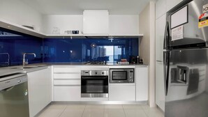 Een moderne keuken met roestvrijstalen apparatuur, een inbouwoven, magnetron en een koelkast.
